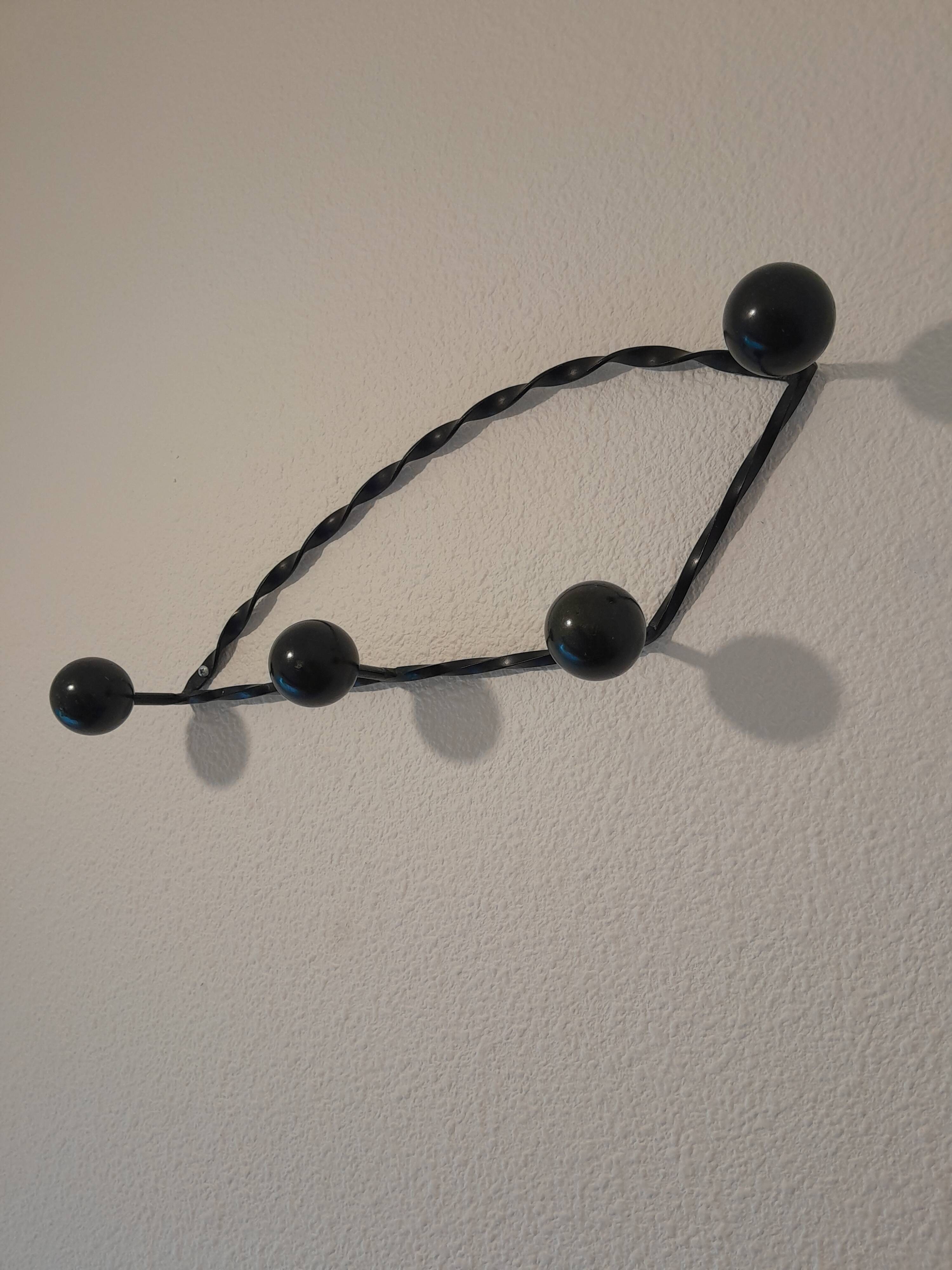 Antique design wall hook in wrought iron and painted wood.