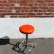 Vintage chrome stool with orange faux leather.