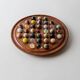 Vintage 1960s solitaire game, wooden board with stone marbles.