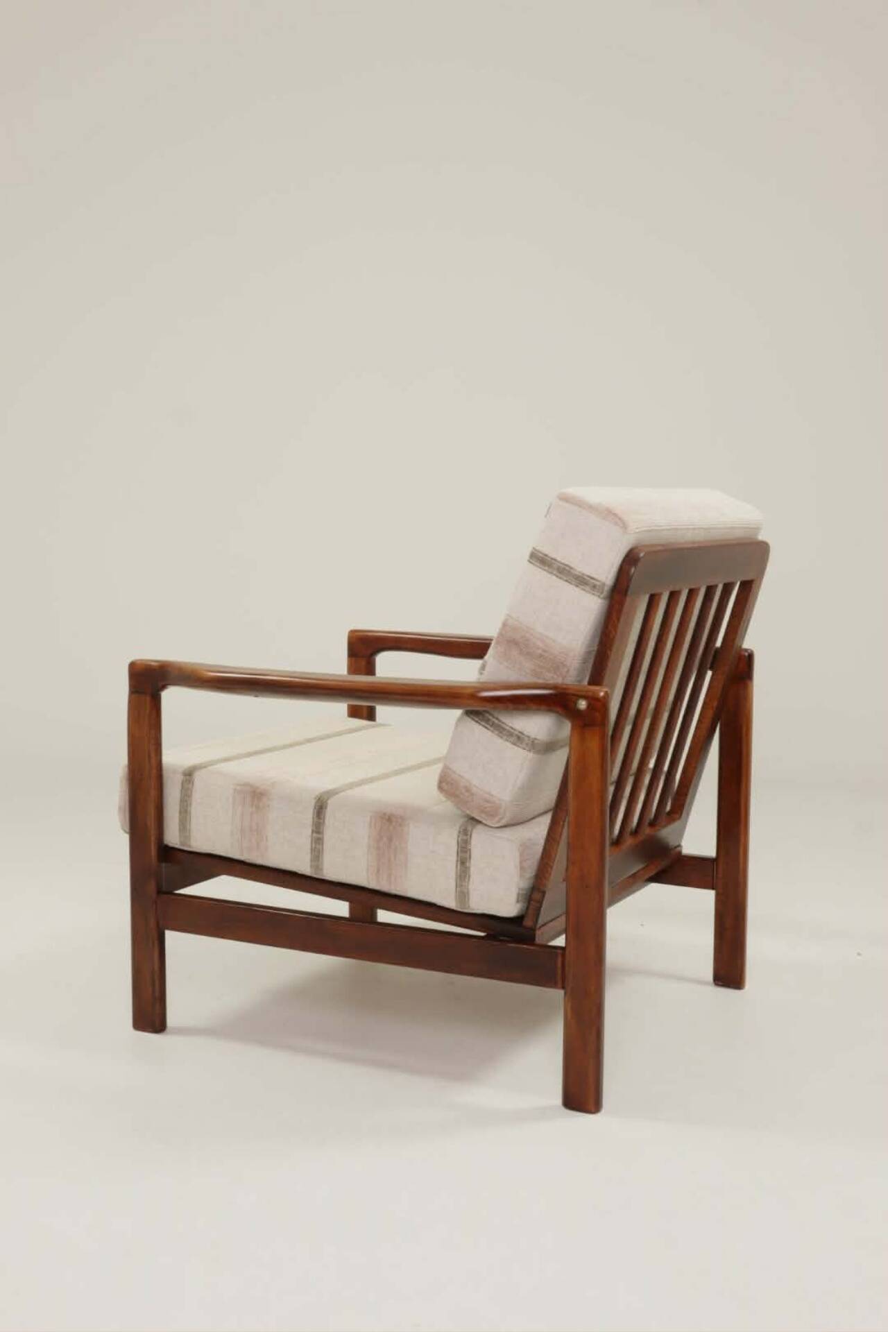 Fauteuil vintage avec des coussins en tissu naturel rayé.