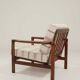 Fauteuil vintage avec des coussins en tissu naturel rayé.