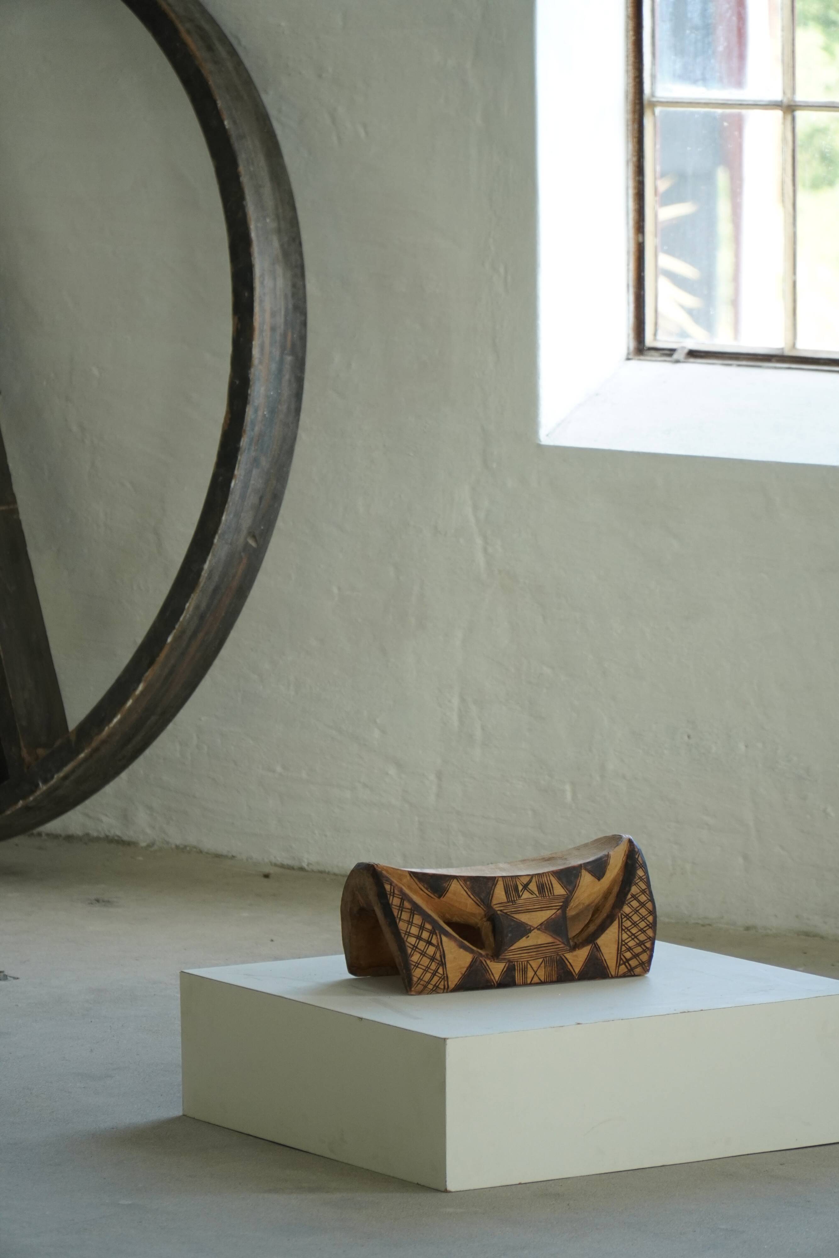 African sculptural stool in wood, hand-carved and adorned with geometric patterns, 1950s.