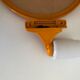 Orange plastic tiltable mirror with its matching wall light.