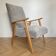 Vintage armchair reupholstered in light grey.