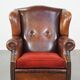 Sheepskin leather wingback chair with a red corduroy seat cushion