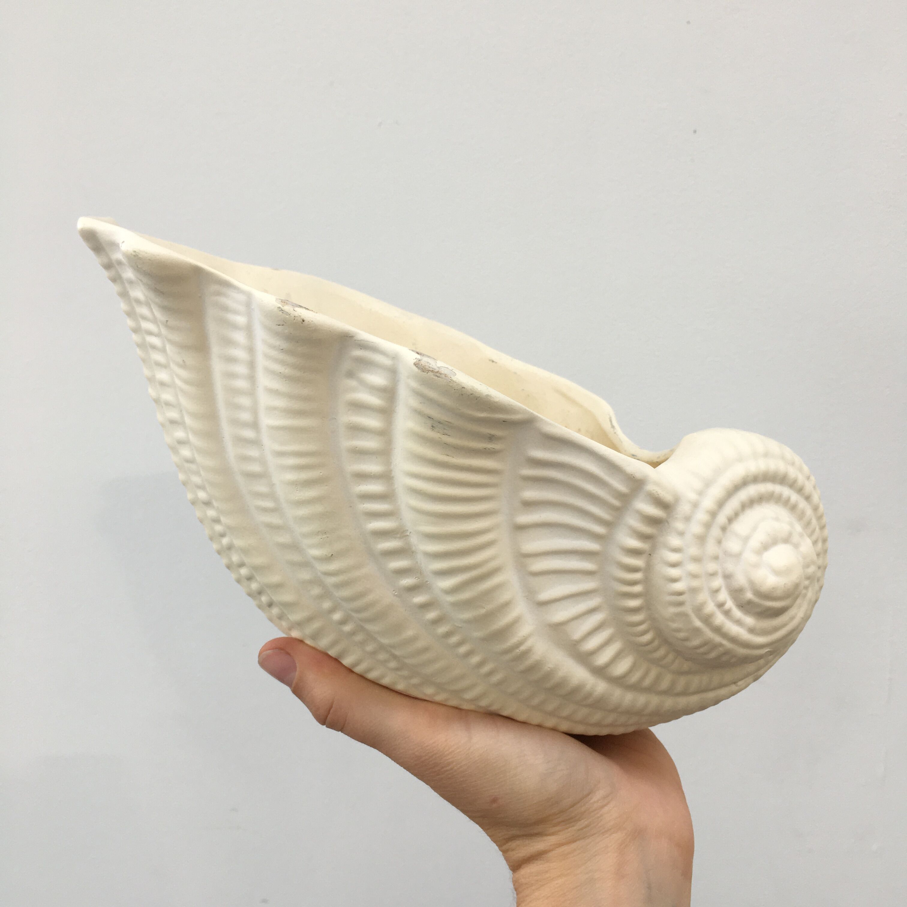 Shell-shaped pot cover in matt white ceramic