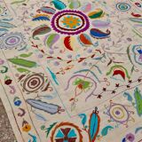 White suzani kilim rug with embroidered multi-colored patterns
