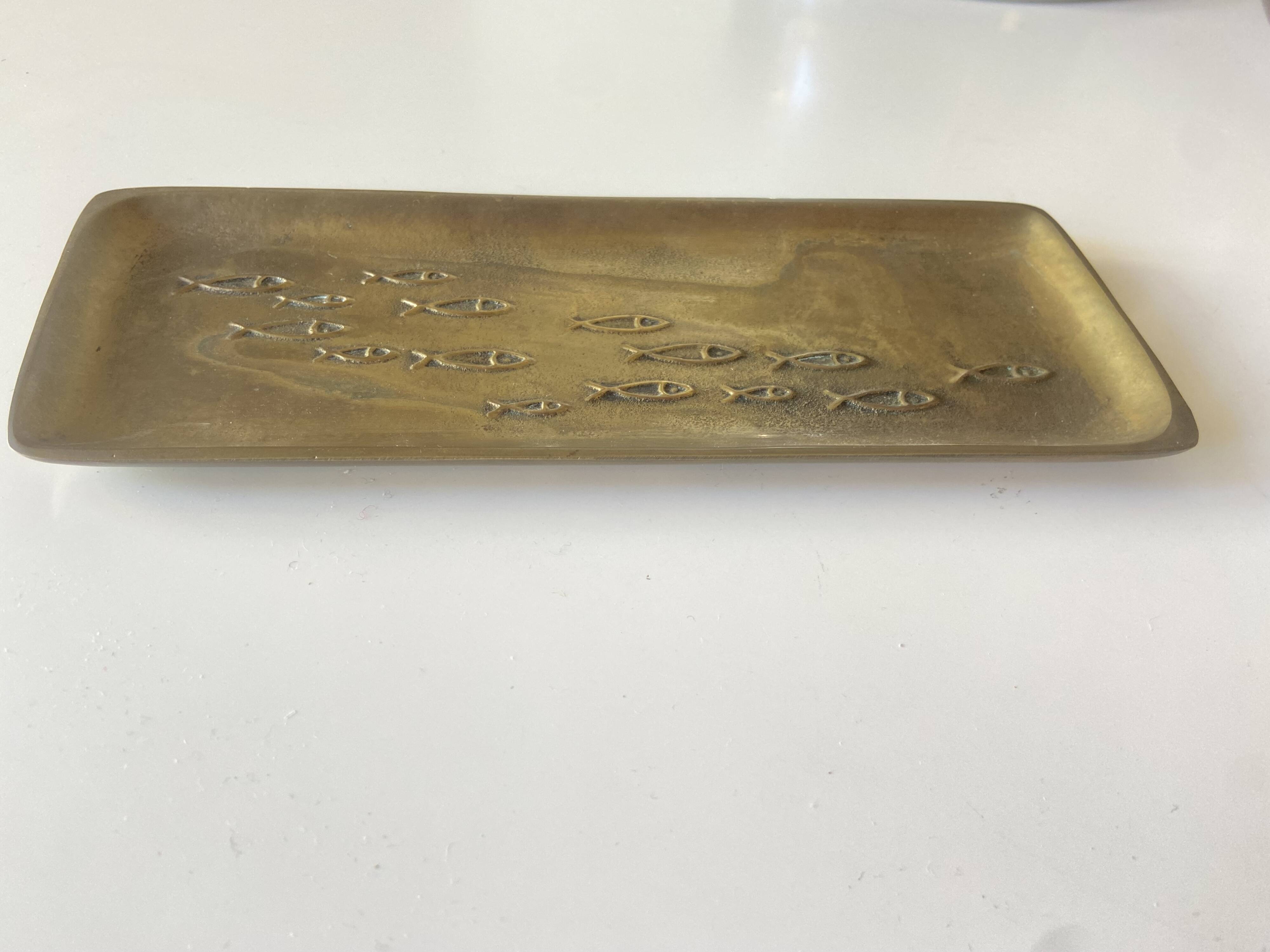 Bronze pocket emptier with fish decoration.