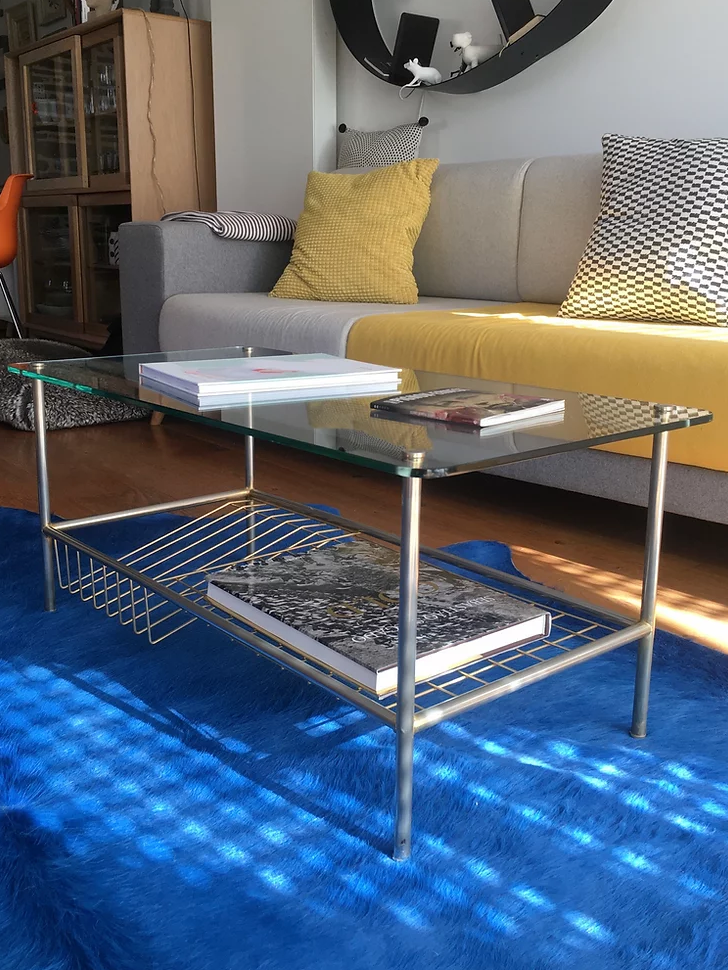 Glass coffee table with gold metal magazine holder