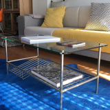 Glass coffee table with gold metal magazine holder
