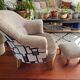 Pair of beige bouclette fabric frog chairs and their footrest.
