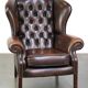 Chesterfield wing chair in dark brown leather with a luxurious appearance