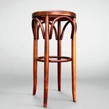 Old high stool in curved wood with caned seat