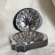 Set of 12 stainless steel scallop shells, 1970s-80s.