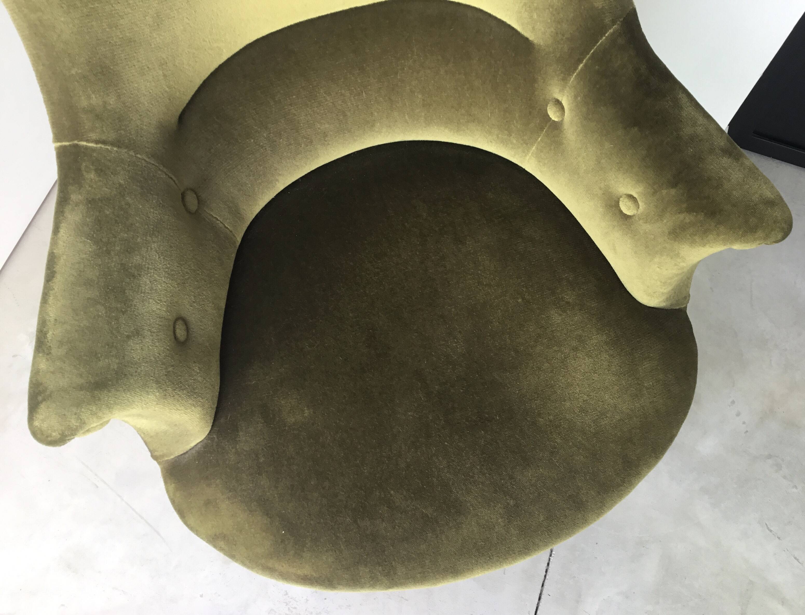 Olive green toad armchair with smooth velvet fringes.