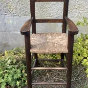 Vintage wooden children's high chair with straw.