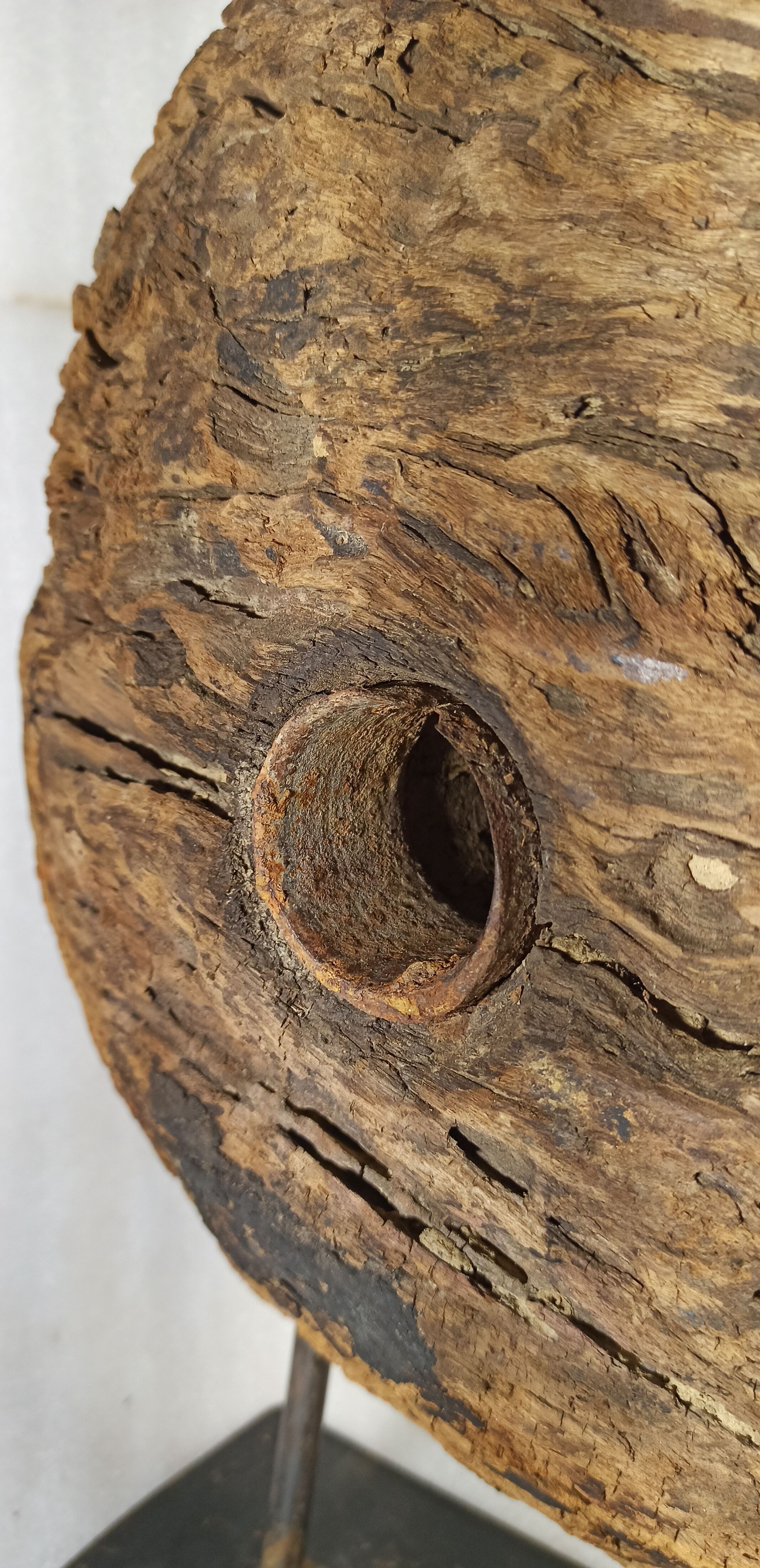 Old wooden pulley wheel on foot