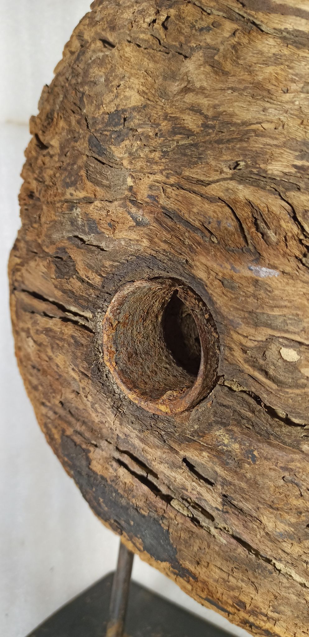 Old wooden pulley wheel on foot