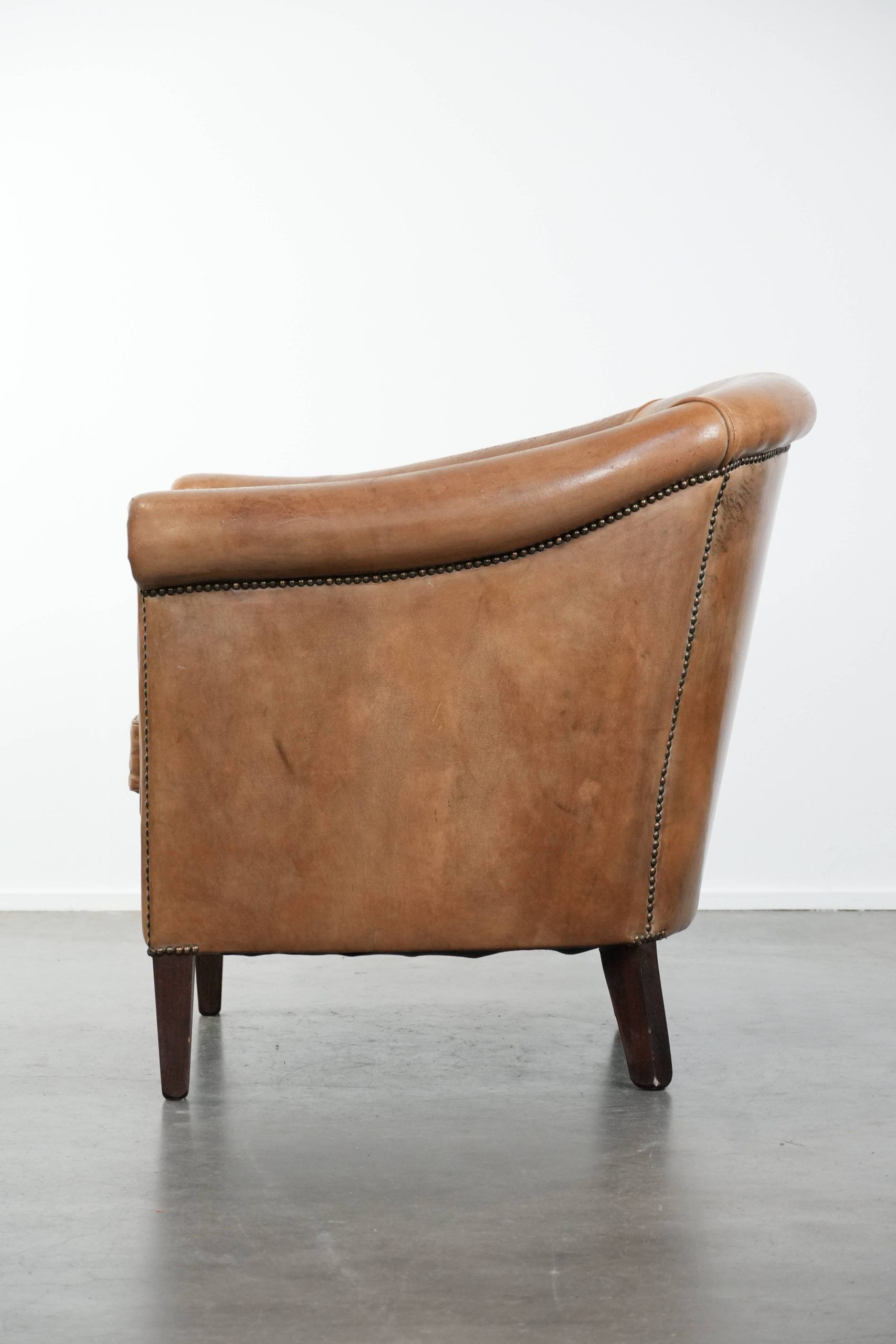 Characterful club chair made of sheepskin leather with light cognac colours