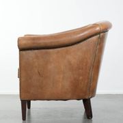Characterful club chair made of sheepskin leather with light cognac colours