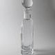 Vintage glass decanter from the 1980s, transparent glass with a silver plate and spherical stopper.