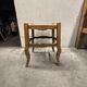 Rustic wooden stool with a straw seat.