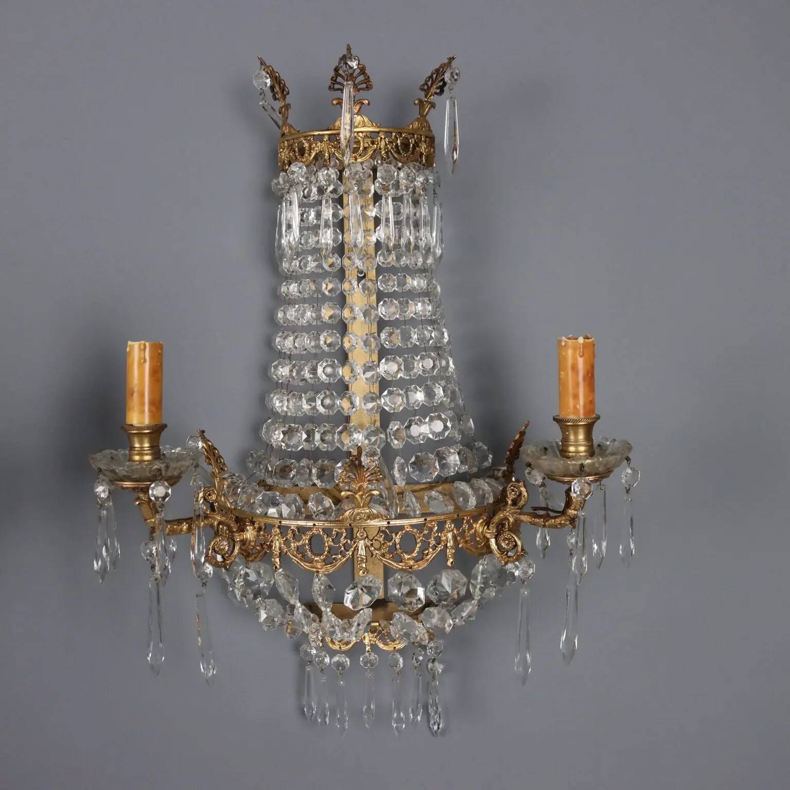Antique wall sconces in gilded bronze with neoclassical motifs, 20th century.