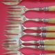 12 Cake forks. Around 1930. Golden metal and yellow Bakelite handle.