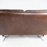 Two seater sofa upholstered with patinated brown leather and frame in metal, designed by Arne Norell