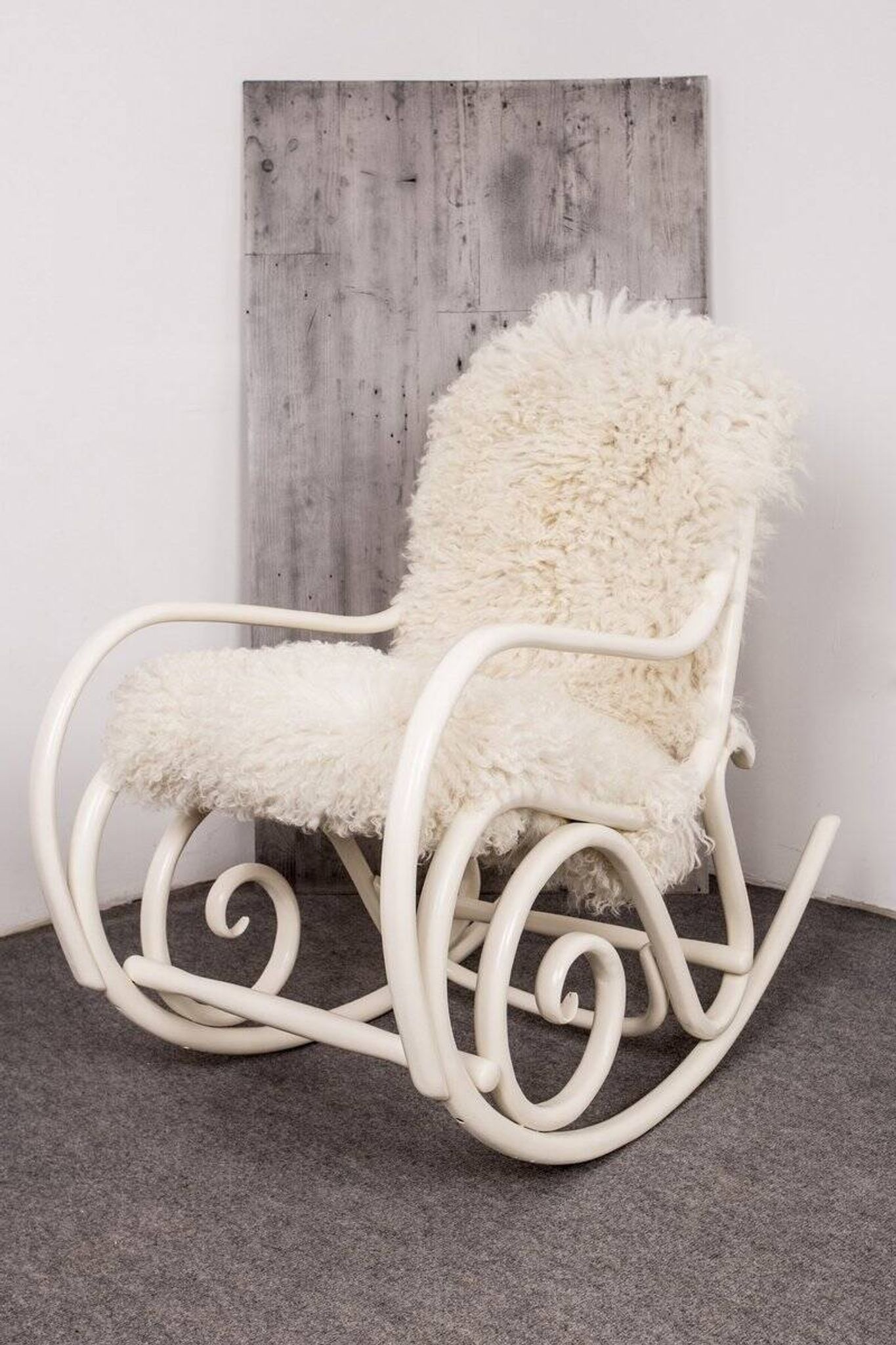 Antique Thonet rocking chair in ivory lacquered bent wood, with a white lamb fur seat.