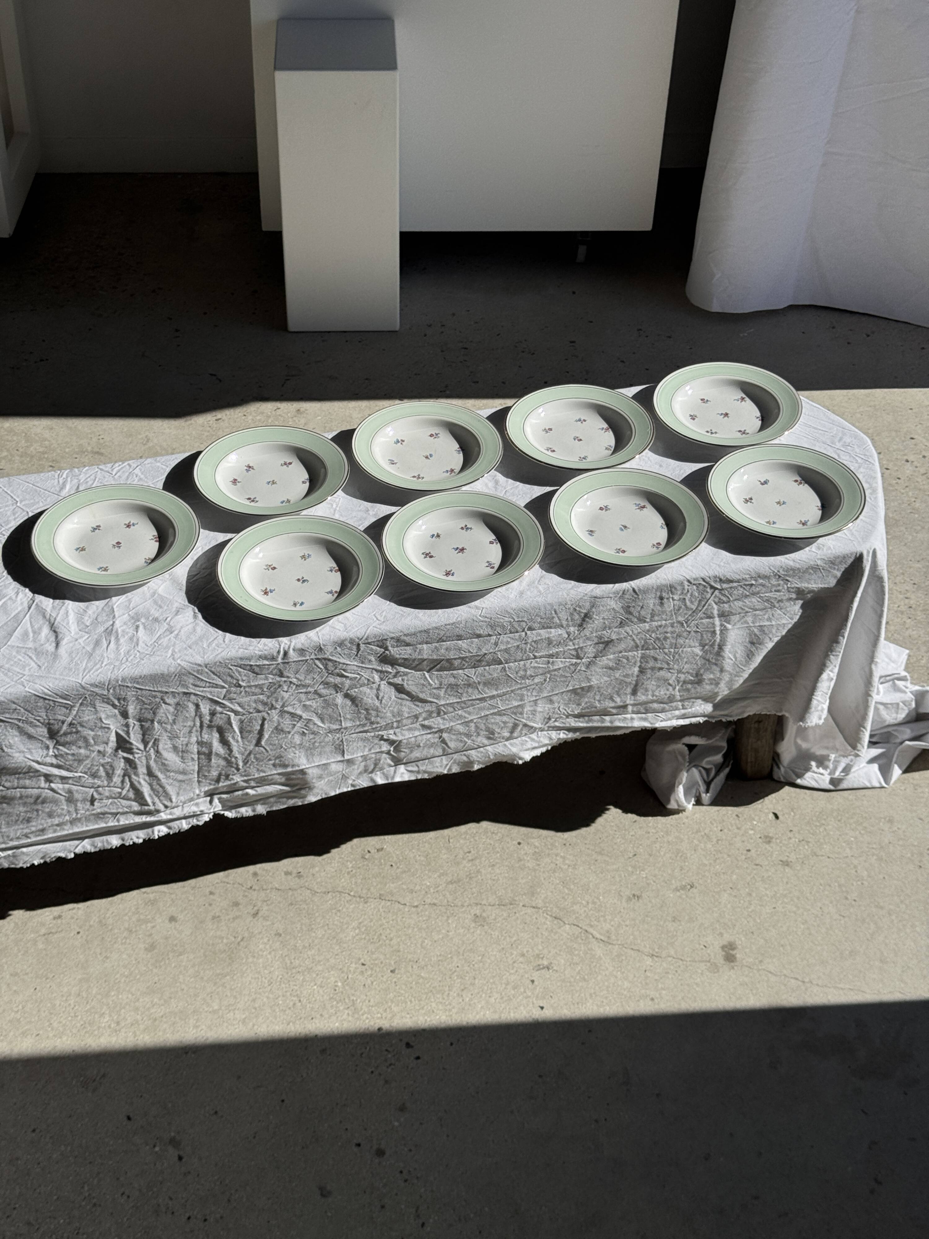 Set of 9 vintage turquoise deep plates with gold trim and pink flowers.