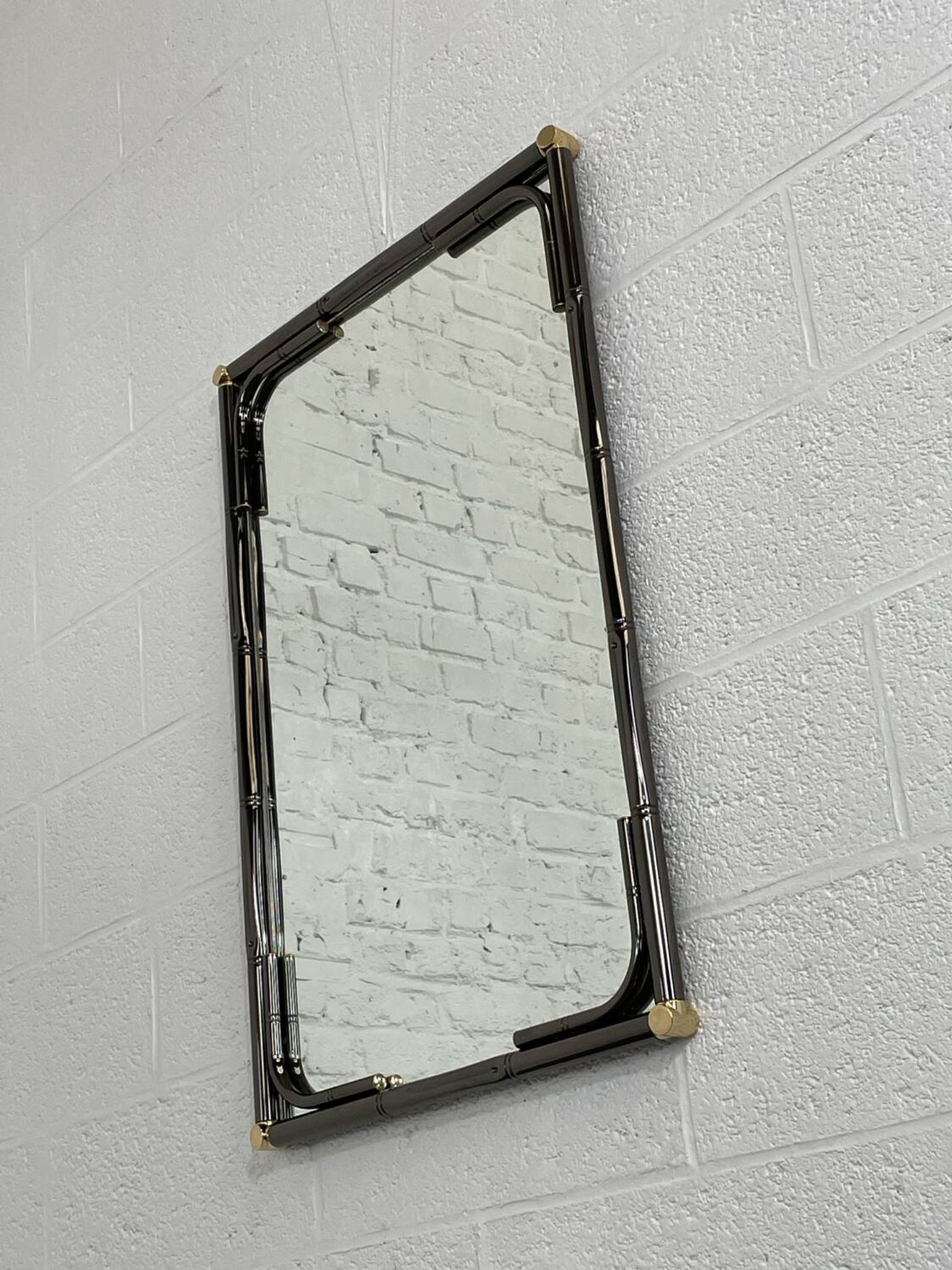 Mirror in black metal and brass with gunmetal finish