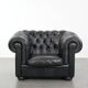 Set of a black cowhide leather Chesterfield armchair and matching ottoman