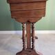 Antique wooden sewing cabinet with mirror and storage.