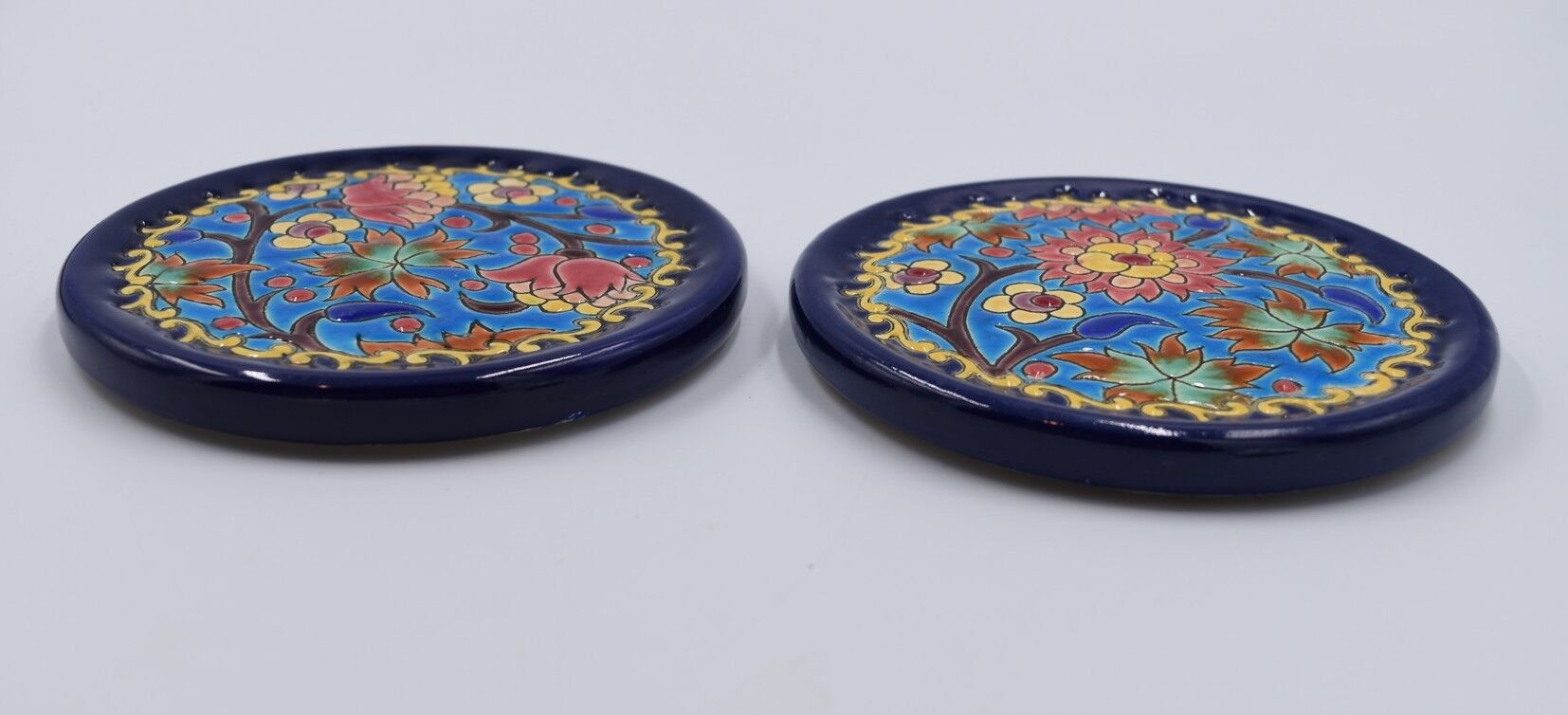 A flat bottom and two enamel bottle bottoms of Longwy