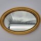 Small old oval mirror in gilded wood