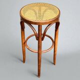 Old high stool in curved wood with caned seat
