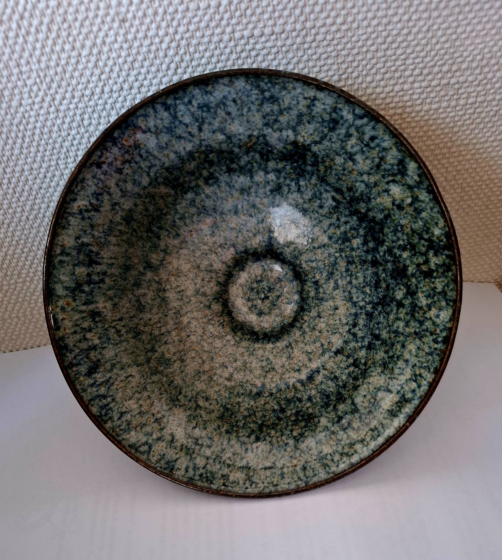 Bowl on a circular base or small blue ceramic dish.
