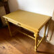 Desk table from the late 19th century, painted mustard, with turned stretcher.