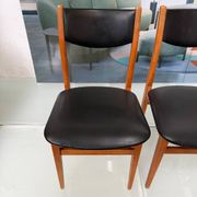 4 Scandinavian chairs in teak and black faux leather.