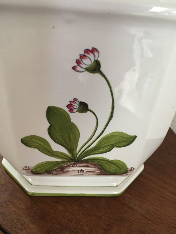 Cover - white ceramic pot decorated with stylized flowers.