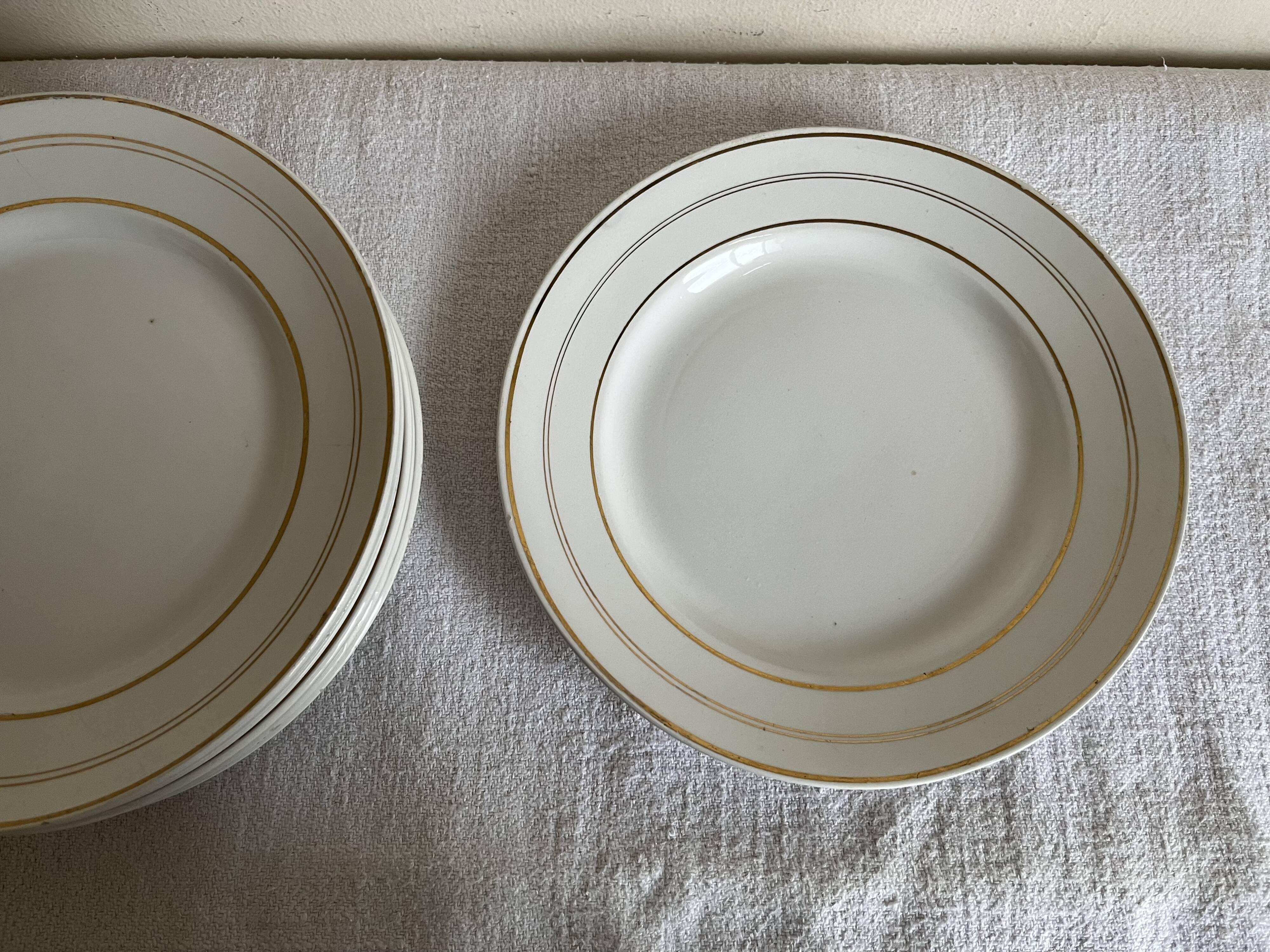 Set of 8 modernist flat plates in fine earthenware with pure gold trim, 1930.