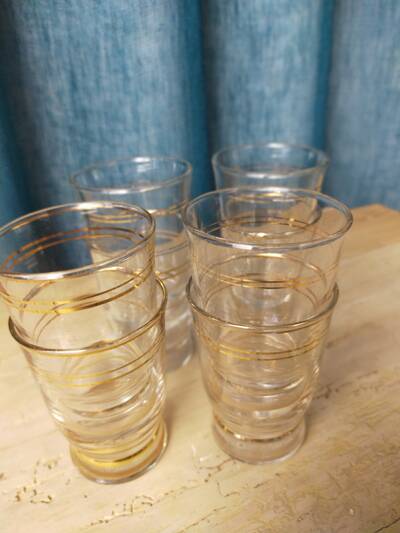 Set of 9 antique glasses with gold rim.