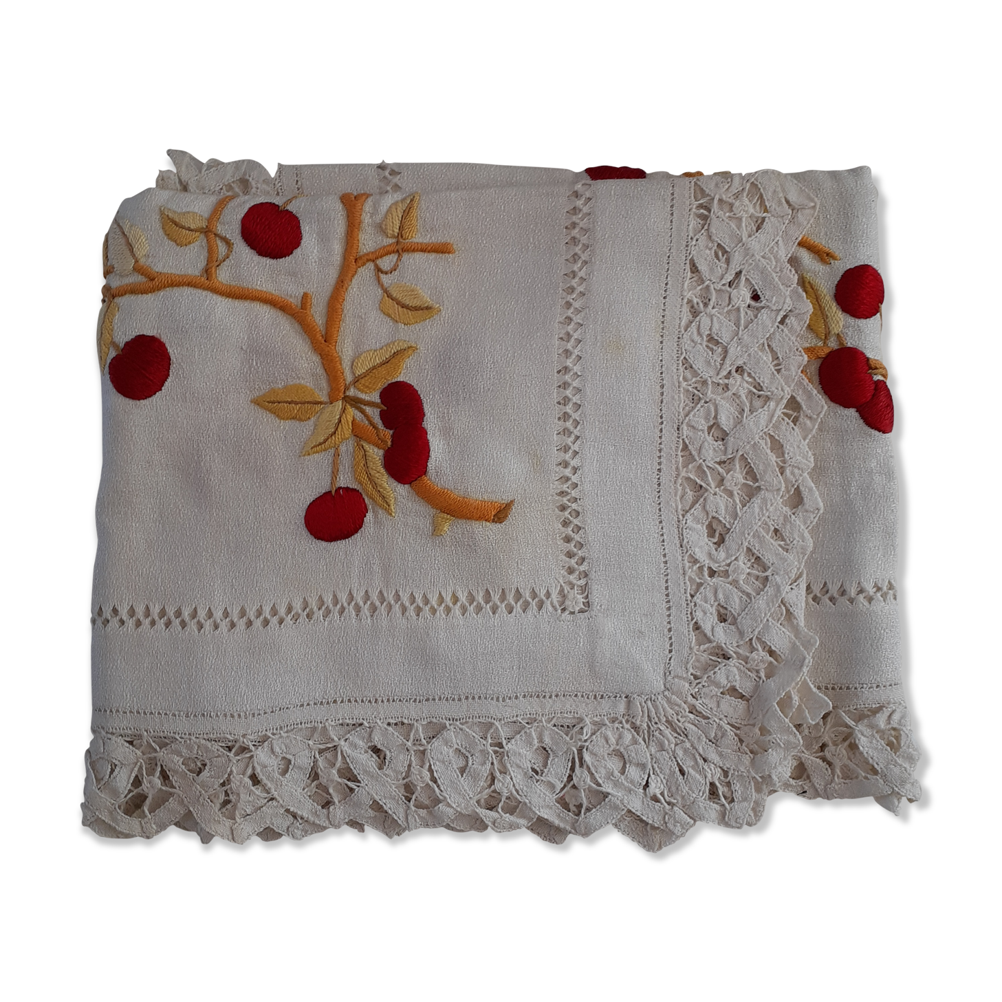Square white doily. Embroidered with red tantrums. Lace entourage and days.
