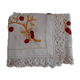 Square white doily. Embroidered with red tantrums. Lace entourage and days.