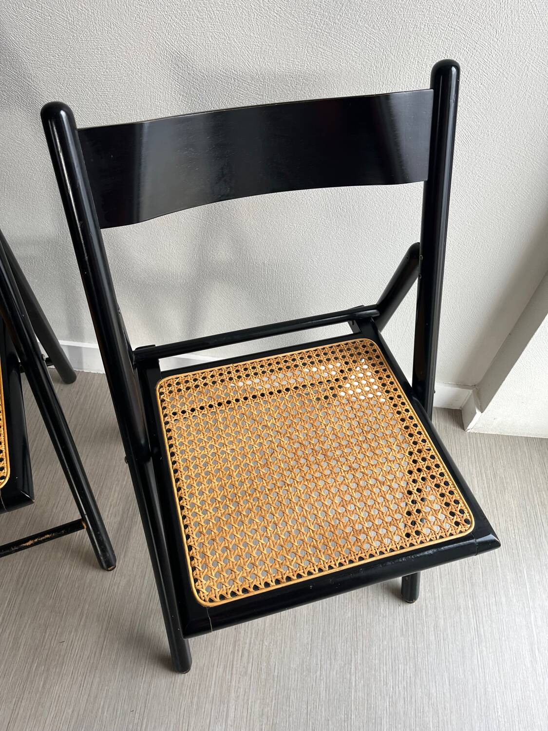 Vintage folding chairs in black wood and cane.