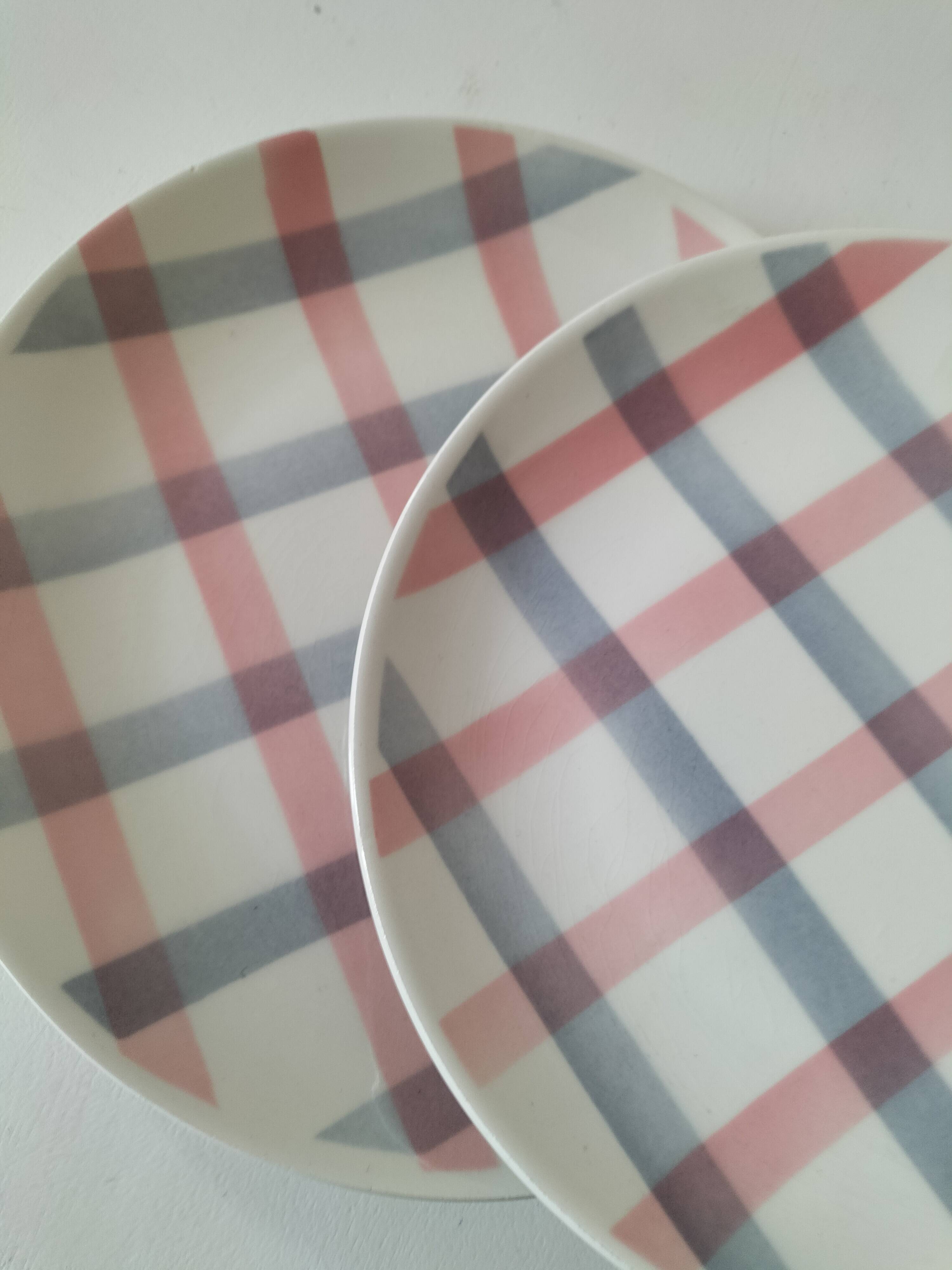 Two dessert plates Moulin des Loups with a pink and grey tablecloth design.