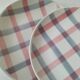 Two dessert plates Moulin des Loups with a pink and grey tablecloth design.