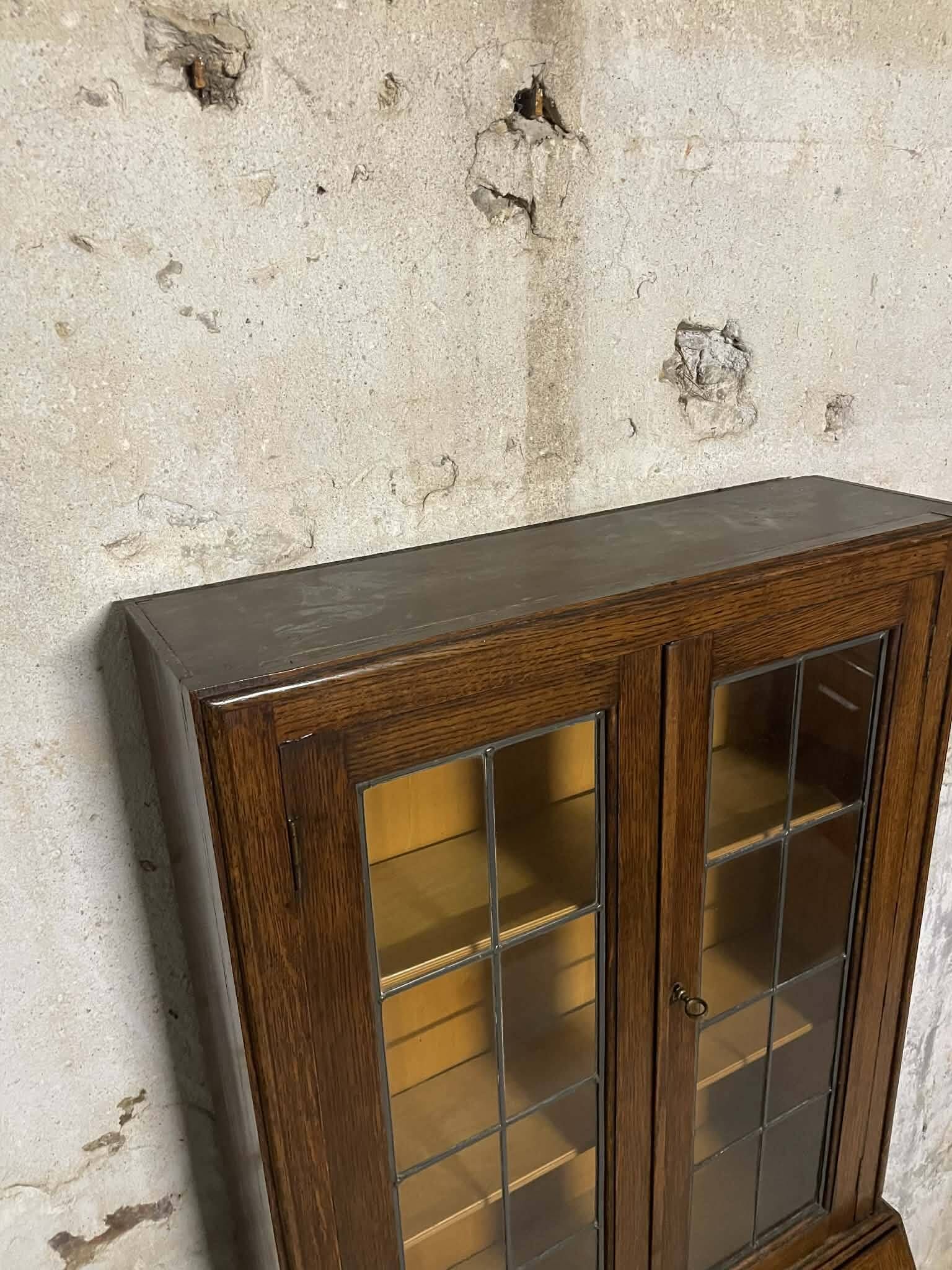 Oak display secretary cabinet with drop-down front, two sections.