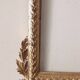 Mirror with a carved wooden frame in an antique style in pure gold.